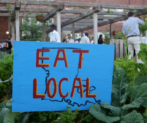 A sign reading "Eat Local" in the edible garden at Samuel J. Green Charter School. (Sabree Hill, UptownMessenger.com)