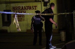 NOPD officers look for evidence at the scene of a November 2012 shooting at the corner of Annunciation and Washington, where about a dozen shell casings were marked on the ground. (UptownMessenger.com file photo by Robert Morris)