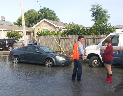 Sewerage and Water Board superintendent Joe Becker speaks with a resident amid flooding from a broken water main on Cohn Street in July 2013. (UptownMessenger.com file photo by Robert Morris)