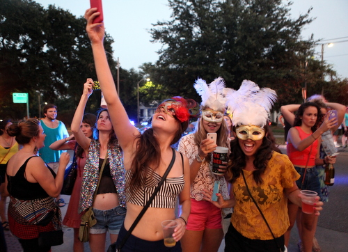 Spectators snap photos as the Krewe of OAK passes. (UptownMessenger.com)