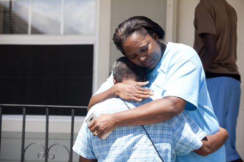 Neighbors comfort each other in the 1300 block of General Ogden St. (Sabree Hill, UptownMessenger.com)