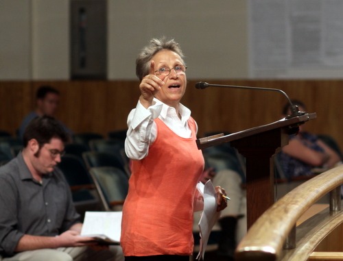 Sylvi Beaumont, owner of the proposed "Engine 37" coffee house in the former Laurel Street fire station, points to a photo of the building as she addresses the City Planning Commission on Tuesday. (Robert Morris, UptownMessenger.com)