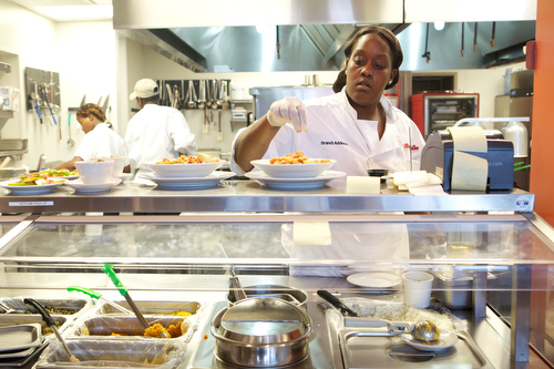 Brandi Addison prepares a pasta dish at Cafe Reconcile Thursday afternoon. (Sabree Hill, UptownMessenger.com)