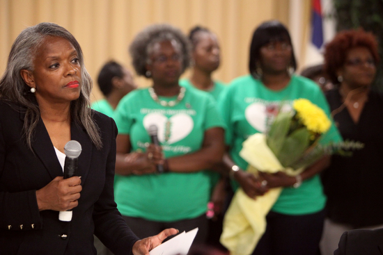 Rev. Pat Watson, executive director of Helping Mothers Heal, stands in front of a group of mothers during a ceremony Thursday evening. (Sabree Hill, UptownMessenger.com)