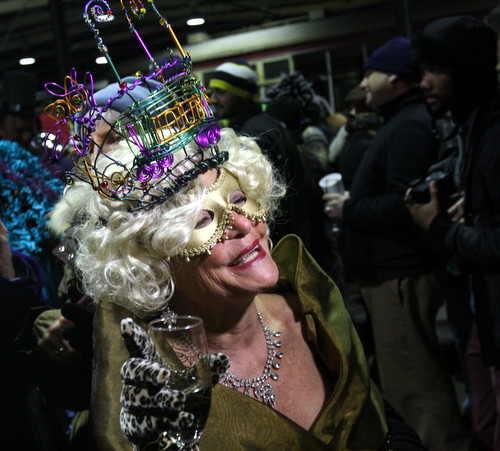 Wearing a streetcar tiara, a member of the Phunny Phorty Phellows wishes everyone a "Happy Mardi Gras" before boarding the St. Charles Avenue streetcar on Monday evening. (Robert Morris, UptownMessenger.com)