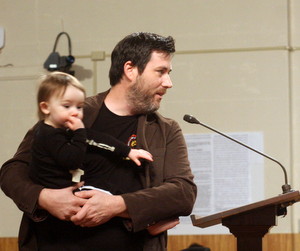 Scott Wood, co-owner of the Courtyard Brewery, speaks to the City Planning Commission on Tuesday with 18-month-old Jules in his arms.