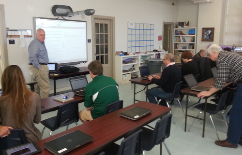 Lusher's operations director Frank Israel leads school board members in taking the state's newest standardized test. (Robert Morris, UptownMessenger.com)