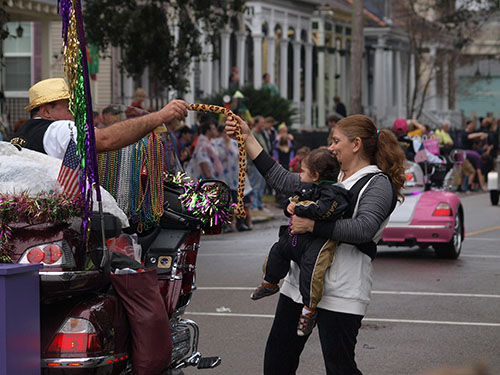 Young parade goer receives a plush toy from a Gold Wing Road Rider. Krewe of Carrollton 2014. (Zach Brien, UptownMessenger.com)
