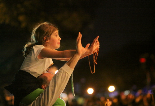 A child waits expectantly for throws from the Krewe of Oshun. (Robert Morris, UptownMessenger.com)
