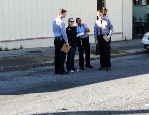 NOPD investigators confer near a gun magazine and shell casings found at the scene of a shooting on O.C. Haley Boulevard on Tuesday. (Robert Morris, UptownMessenger.com)
