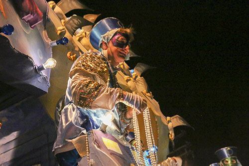 Rider from the "Deep Sea Fishing in the Gulf" float prepares to throw beads to the crowd.