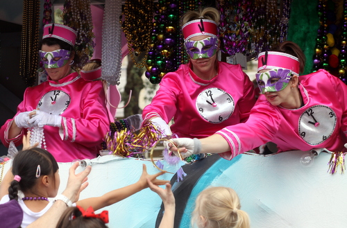 Riders in the Krewe of Iris hand throws to the crowd. (Robert Morris, UptownMessenger.com)