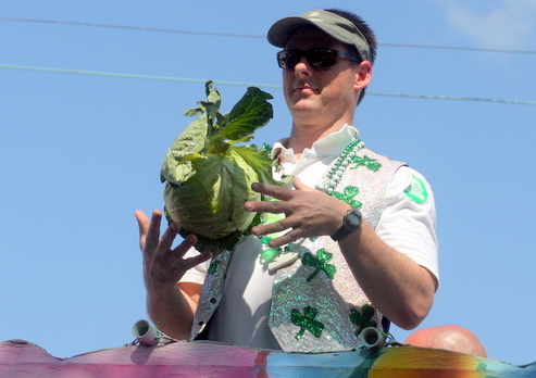 A rider in the 2012 St. Patrick's Day parade prepares to throw a cabbage to the crowd. (UptownMessenger.com file photo by Robert Morris)