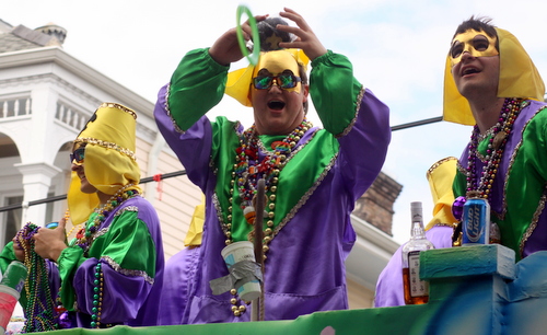 A rider in the Krewe of Okeanos holds a throw over the crowd. (Robert Morris, UptownMessenger.com)