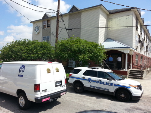 Coroner's officials and homicide investigators surround an apartment in the 2600 block of South Claiborne Avenue. (Robert Morris, UptownMessenger.com)