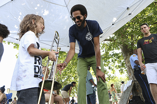 Trombonist Michael Watson of the New Orleans Jazz Orchestra allowed interested kids to play his trombone. (Zach Brien, UptownMessenger.com)