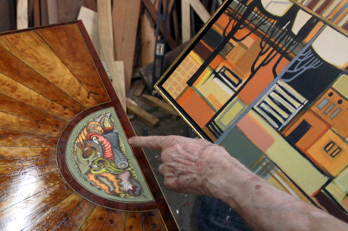 Ruppert Kohlmaier, a well-known New Orleans woodworker, gestures to the inlay he is designing on a custom chest of drawers in his shop next to the controversial green space. (Robert Morris, UptownMessenger.com)