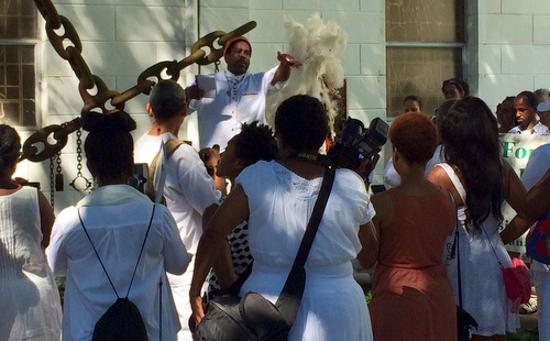 A participant in the Maafa ceremony speaks at the Tomb of the Unknown Slave. (photo by jewel bush for UptownMessenger.com)