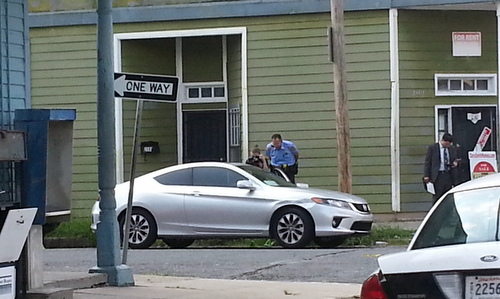 Evidence cones can be seen from underneath a car parked at Second and Dryades streets, where a man was wounded in a shooting Wednesday. (Robert Morris, UptownMessenger.com)
