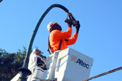 Anthony Reed installs a new LED light on a St. Charles Avenue streetlight pole. (Robert Morris, UptownMessenger.com)