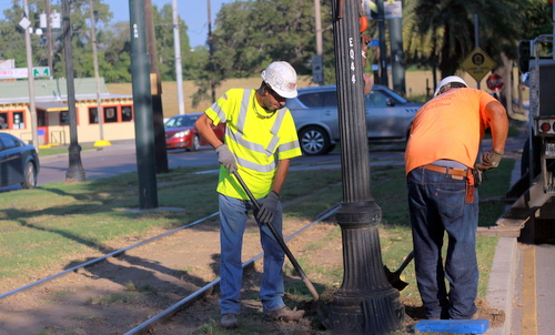 Joey Saluto and Darrick Lavais of All-Star Electric dig around the base of a streetlight on St. Charles Avenue. (Robert Morris, UptownMessenger.com)