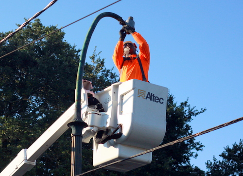 Anthony Reed of All-Star Electric prepares to move an old fixture from a streetlight on St. Charles Avenue near Carrollton on Monday morning. (Robert Morris, UptownMessenger.com)