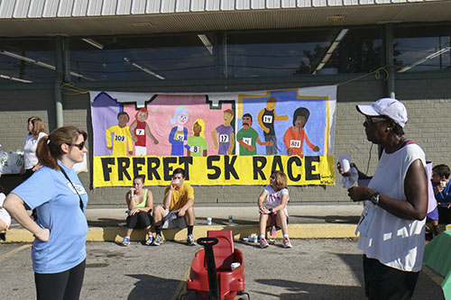 Freret 5K sign, hand painted by students from McMain charter school, hung on the wall of the Junior League of New Orleans' Boomin' Deals Thrift Store. (Zach Brien, UptownMessenger.com)