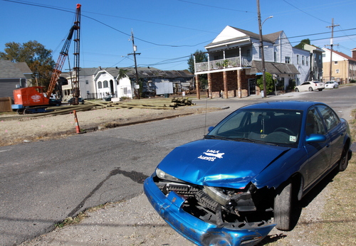 A damaged blue Saturn sits in the 2000 block of Foucher, after a fatally wounded woman was found in a Mercedes that crashed into it. (Robert Morris, UptownMessenger.com)