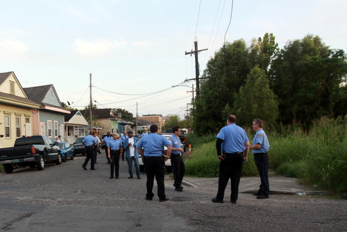 New Orleans Police officers gather around the vacant lot at Foucher and South Saratoga for an anti-crime march in late September, when the property was still covered in tall weeds. (UptownMessenger.com file photo by Robert Morris)