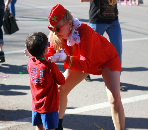 A dancer in the Amelia Earhawts troupe greets a spectator during the Krewe of King Arthur parade. (Robert Morris, UptownMessenger.com)