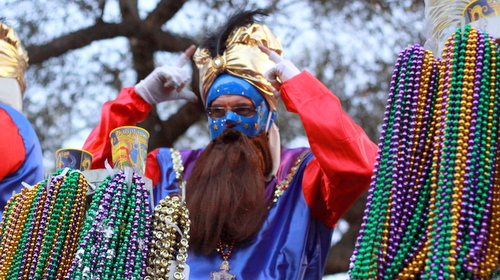 A rider on the Babylon "Stargazer" float motions someone in the crowd to don the headgear he threw. (Robert Morris, UptownMessenger.com)