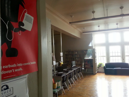 A glimpse inside the Lusher High School library shows bookshelves next to rows of computers, along with posters urging students to keep reading in the technology age. (Robert Morris, UptownMessenger.com)