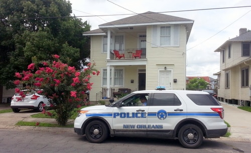 A NOPD officer guards a house where a man died of a gunshot that police say may have been self-inflicted. (Robert Morris, UptownMessenger.com)