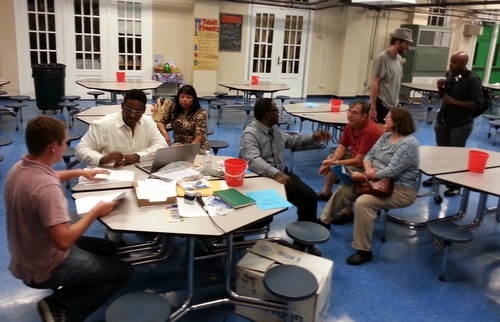 Matthew Brichetto and Stan Norwood (from left) count ballots while Alba Sanabria watches, and Glenis Scott speaks to Richard and Jane Dimitry at the end of the Freret Neighbors United meeting. (Robert Morris, UptownMessenger.com)