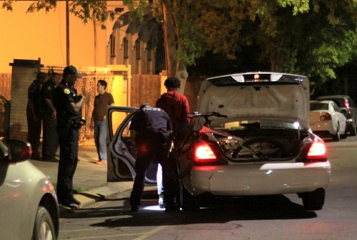 Police search a teen suspect arrested on a gun charge Friday night on Milan Street near St. Charles Avenue. (Robert Morris, UptownMessenger.com)