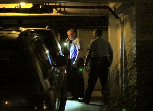 Detectives look for evidence in a Milan Street garage on Friday night. (Robert Morris, UptownMessenger.com)