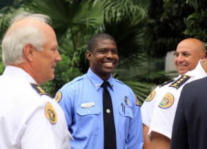 NOPD Officer Everette Route smiles as he's congratulated by Deputy Chief Bob Bardy (left) and Sixth District Commander Ronnie Stevens for his role stopping a robbery suspect Friday night. (Robert Morris, UptownMessenger.com)