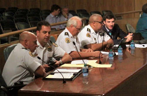 NOPD Commanders Ronnie Stevens and Paul Noel (from left), Deputy Chief Bob Bardy, Chief Michael Harrison, and spokesman Tyler Gamble confer prior to a hearing before the City Council on Friday. (Robert Morris, UptownMessenger.com)