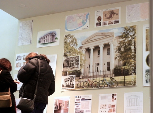 Two attendees at Thursday's presentation on the Carrollton Courthouse at Tulane University examine plans and documents produced by architecture students. (Robert Morris, UptownMessenger.com)