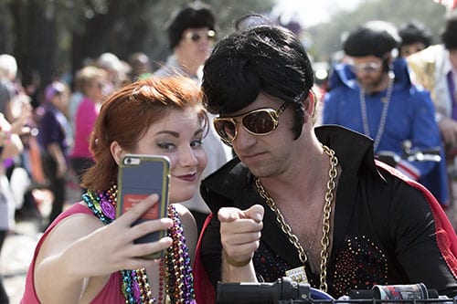 Alayna Dermid, left, takes a picture with a member of the Jailhouse Rockers in the Krewe of Carrollton. The Krewe of Carrollton was one of four parades that rolled uptown on Sunday. (Zach Brien, UptownMessenger.com)
