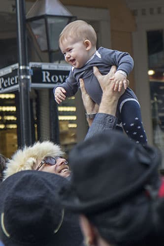 A man plays with child on the corner of St. Peter and Royal in the French Quarter before the David Bowie parade. On Saturday, the Preservation Hall Jazz Band and members of Arcade Fire led a second line through the French Quarter in honor of musician David Bowie who died on January 10, 2016.