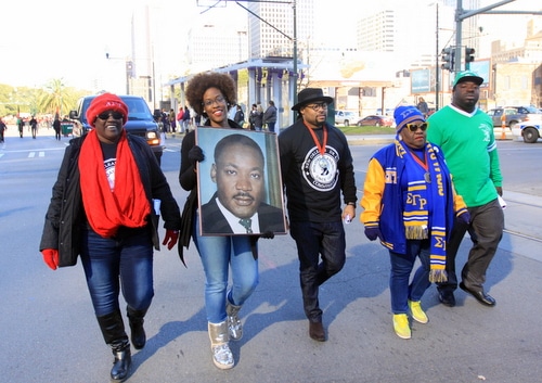 Marchers carry a portrait of Dr. Martin Luther King Jr. at the front of the parade on Loyola Avenue. (Robert Morris, UptownMessenger.com)