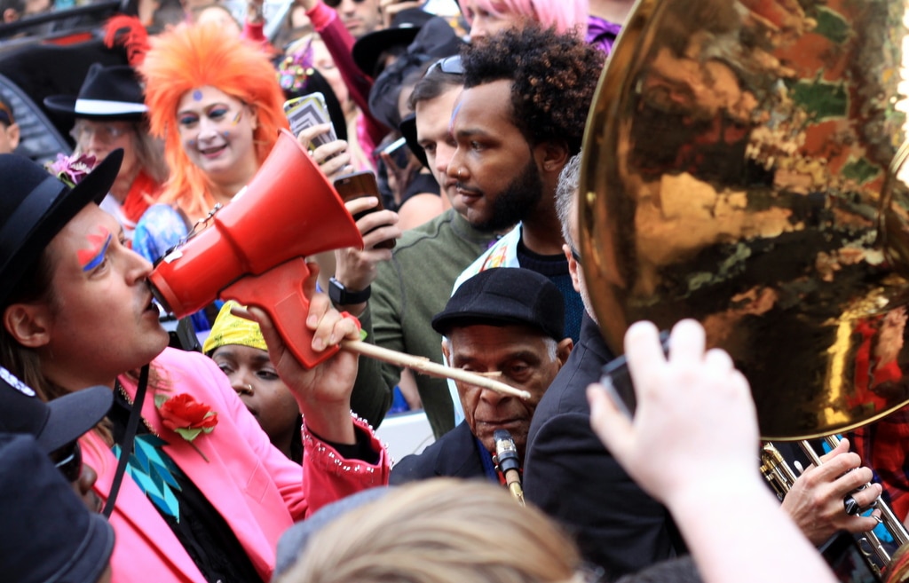 Musician Win Butler of Arcade Fire sings "Oh You Pretty Things" into a megaphone on St. Peter Street in the French Quarter during Saturday's second-line tribute to David Bowie. (Robert Morris, UptownMessenger.com)