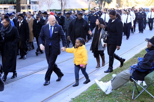 Mayor Mitch Landrieu confers with a young constituent as they march in the parade. (Robert Morris, UptownMessenger.com)
