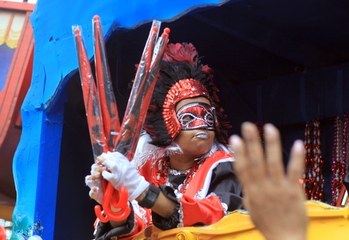A rider teases the crowd with umbrellas as the Mystic Krewe of Femme Fatale rolls on St. Charles Avenue. (Robert Morris, UptownMessenger.com)