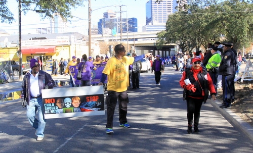 Marchers carry a sign protesting street violence. (Robert Morris, UptownMessenger.com)