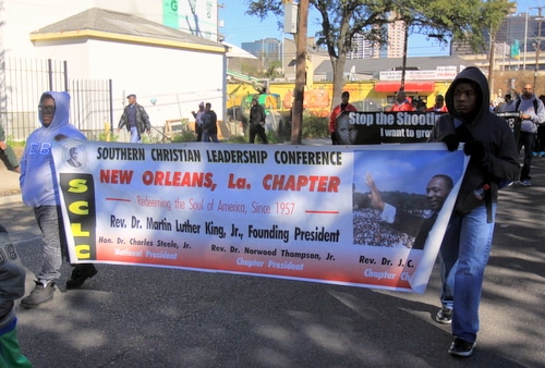 Marchers carry a banner describing the history of the founding of King's Southern Christian Leadership Conference in New Orleans. (Robert Morris, UptownMessenger.com)