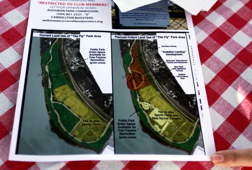 An attendee examines a flyer handed out at the "Save The Fly" rally on Sunday. (Robert Morris, UptownMessenger.com)