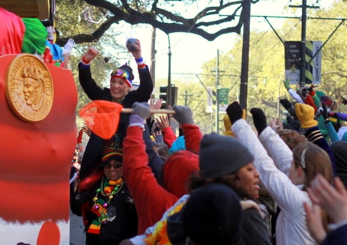 A parade goer celebrates receiving a coconut as the Krewe of Zulu rolls on St. Charles Avenue. (Robert Morris, UptownMessenger.com)