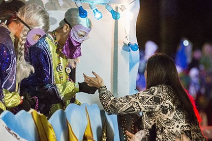 A rider on the "Bacchanahoppa" float gives beads to an eager attendee. Bacchus 2016 rolled with the theme "Flights of Delight." (Zach Brien, UptownMessenger.com)